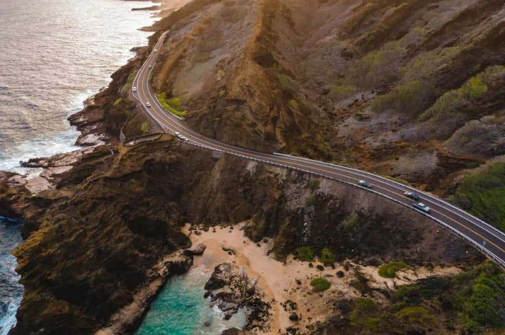 scenic oahu road trip aerial-shot-of-the-narrow-highway-along-the-beach