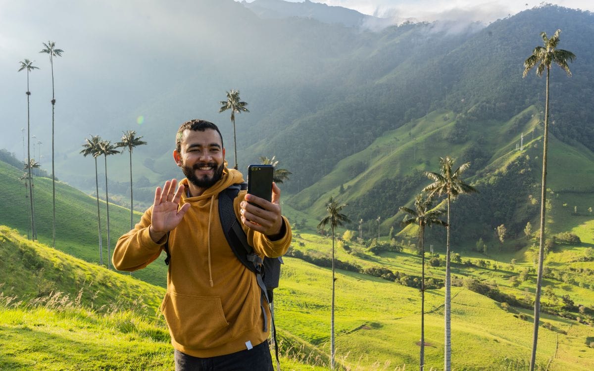 How to Start a Travel Vlog: a man taking a selfie on a mountain